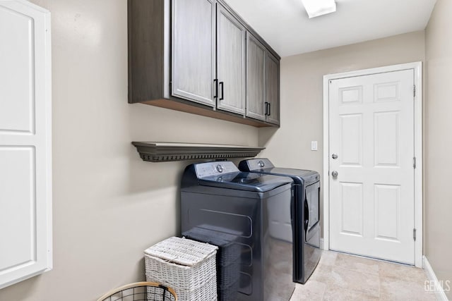 washroom with separate washer and dryer and cabinets