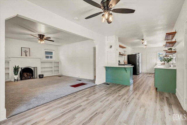 930 S Roosevelt Ave, Fresno, CA 93728 - unfurnished living room featuring a ceiling fan, light wood finished floors, a fireplace, and baseboards