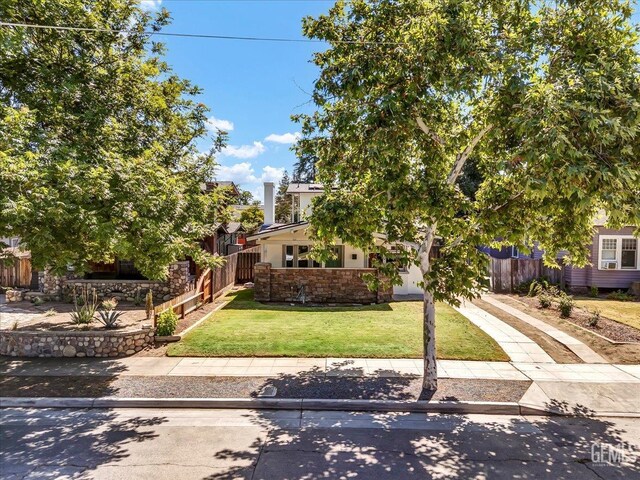 930 S Roosevelt Ave, Fresno, CA 93728 - view of property hidden behind natural elements with driveway, stone siding, and stucco siding