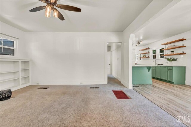 930 S Roosevelt Ave, Fresno, CA 93728 - unfurnished living room with ceiling fan, baseboards, a sink, and light colored carpet