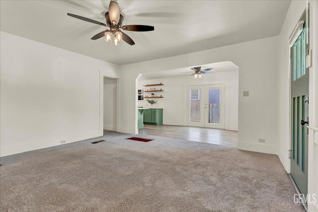 930 S Roosevelt Ave, Fresno, CA 93728 - unfurnished living room featuring a ceiling fan, light carpet, arched walkways, and baseboards