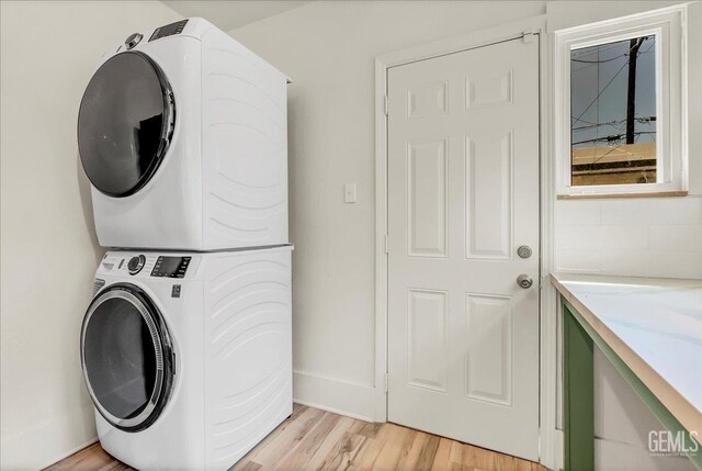 930 S Roosevelt Ave, Fresno, CA 93728 - laundry area with stacked washer / dryer, light wood-type flooring, and baseboards