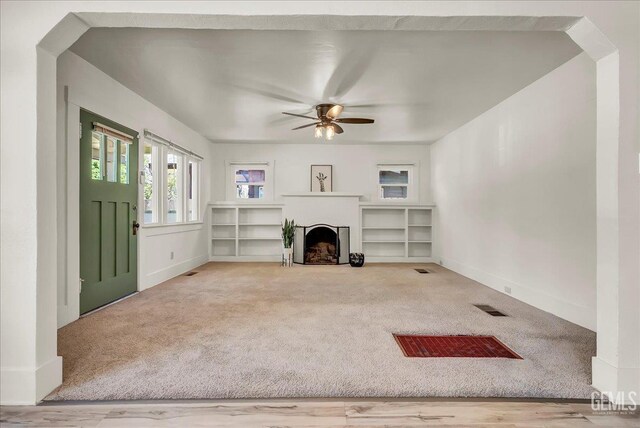 930 S Roosevelt Ave, Fresno, CA 93728 - unfurnished living room with carpet flooring, ceiling fan, a fireplace, and arched walkways