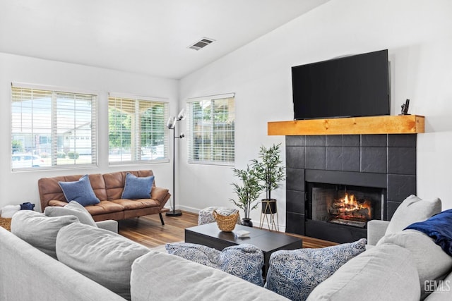 6418 Abby Rose Ave, Bakersfield, CA 93308 - living room with vaulted ceiling, wood finished floors, a tile fireplace, and baseboards