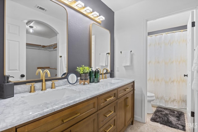 6418 Abby Rose Ave, Bakersfield, CA 93308 - bathroom featuring double vanity, toilet, and a spacious closet