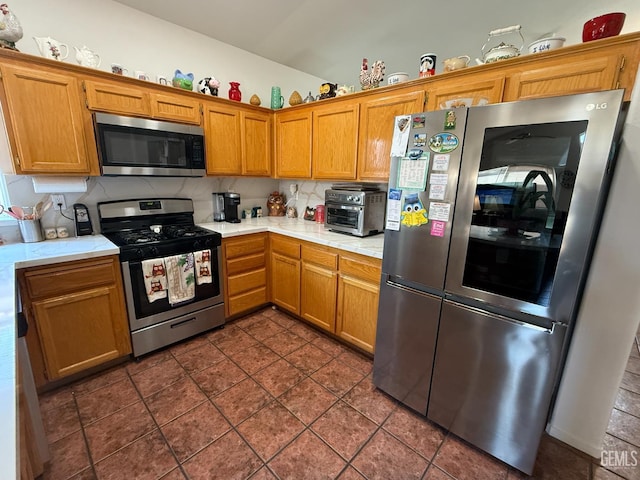 3910 Mariana Way, Bakersfield, CA 93311 - kitchen featuring appliances with stainless steel finishes, light countertops, and brown cabinets