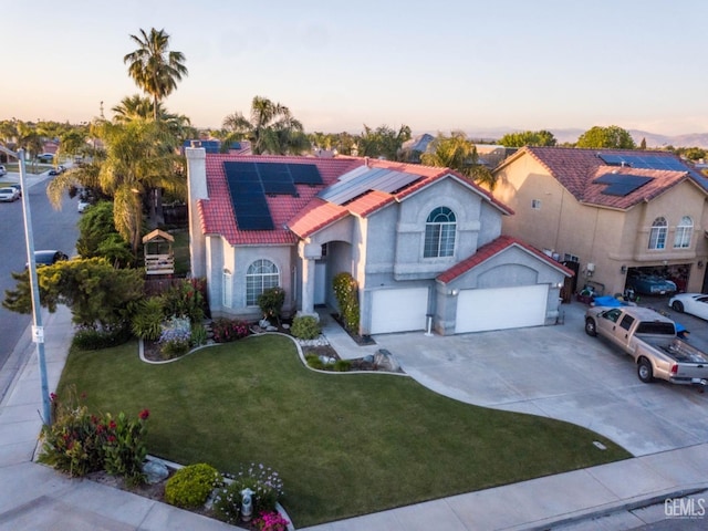 mediterranean / spanish-style house featuring a garage, a lawn, and solar panels