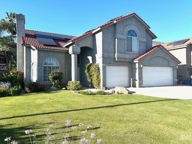 view of front of property featuring a garage, a front yard, and solar panels