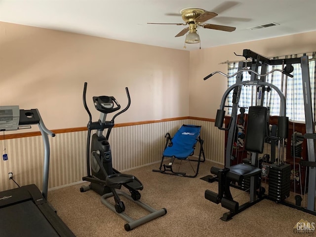 exercise area with ceiling fan and light colored carpet