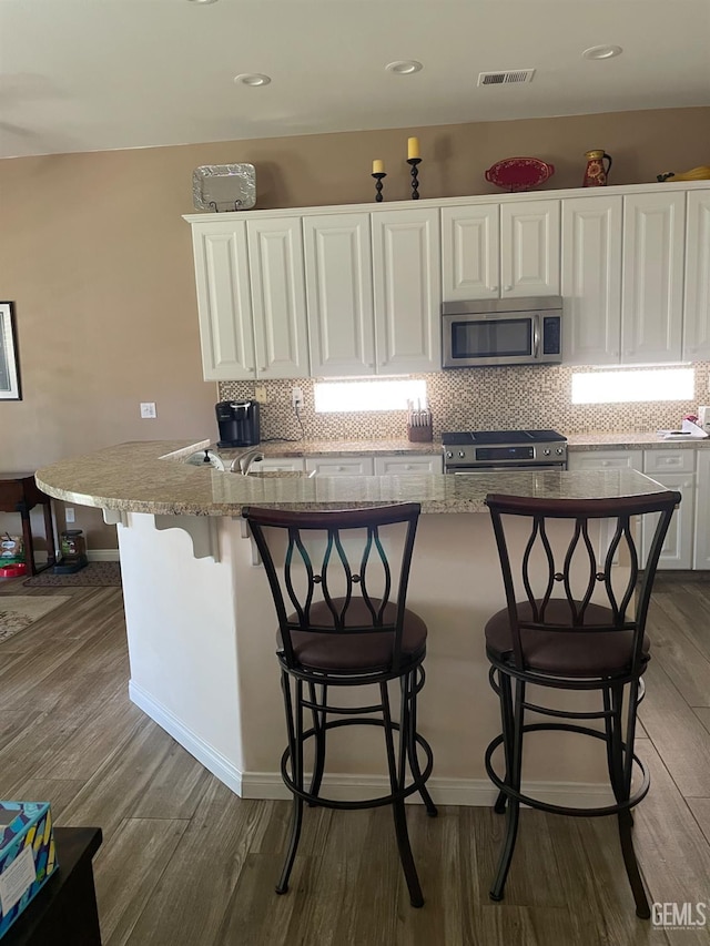 10011 Rosebud Ave, Bakersfield, CA 93311 - kitchen with appliances with stainless steel finishes, white cabinets, dark wood-style flooring, and recessed lighting