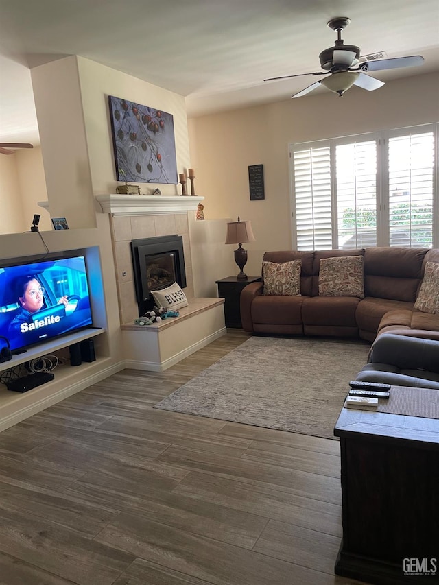 10011 Rosebud Ave, Bakersfield, CA 93311 - living room with a ceiling fan, a tiled fireplace, wood finished floors, and baseboards