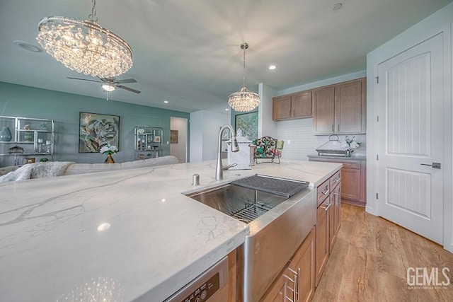 11022 Irontooth Ave, Bakersfield, CA 93311 - kitchen with a chandelier, ceiling fan, light stone countertops, brown cabinets, and recessed lighting