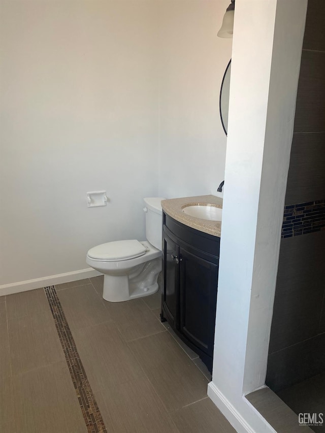 bathroom with tile patterned flooring, vanity, and toilet