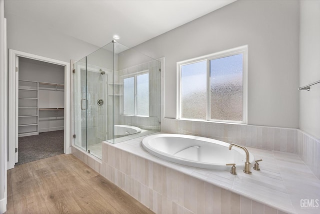 205 Goertzen Ave, Shafter, CA 93263 - bathroom featuring a shower stall, a garden tub, a spacious closet, and wood finished floors