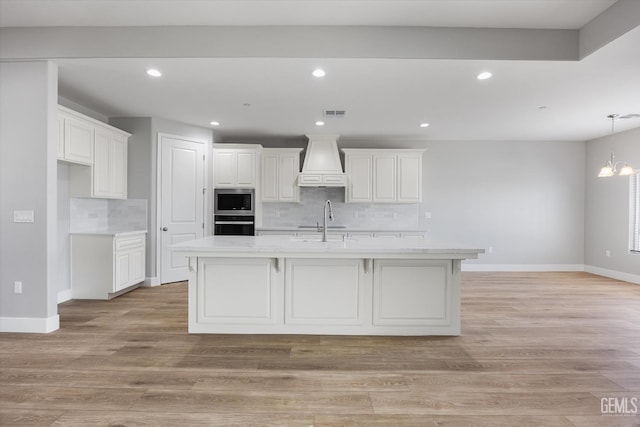 205 Goertzen Ave, Shafter, CA 93263 - kitchen with stainless steel microwave, custom range hood, backsplash, oven, and recessed lighting