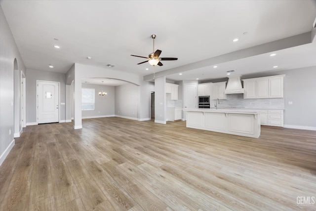 205 Goertzen Ave, Shafter, CA 93263 - unfurnished living room featuring arched walkways, ceiling fan, recessed lighting, light wood-style floors, and a chandelier