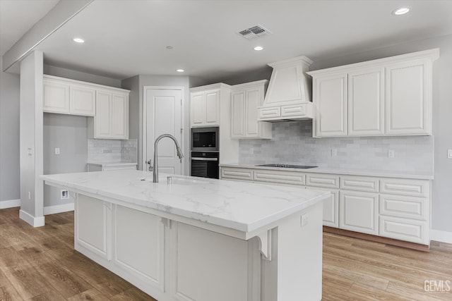205 Goertzen Ave, Shafter, CA 93263 - kitchen with custom exhaust hood, black appliances, white cabinetry, backsplash, and recessed lighting