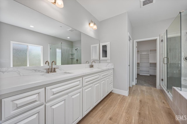 205 Goertzen Ave, Shafter, CA 93263 - full bath featuring double vanity, a shower stall, a spacious closet, and wood finished floors