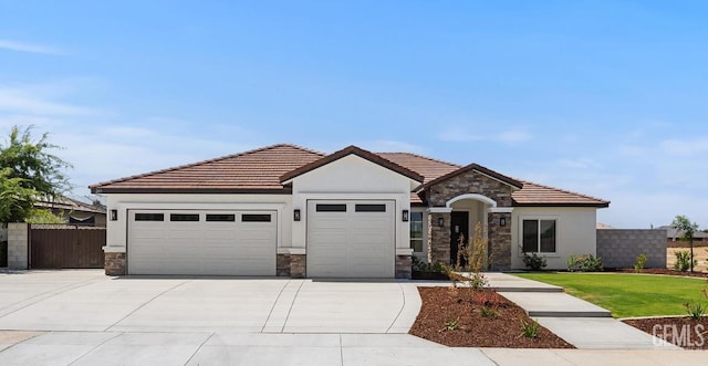 205 Goertzen Ave, Shafter, CA 93263 - view of front of property with stone siding, an attached garage, and stucco siding