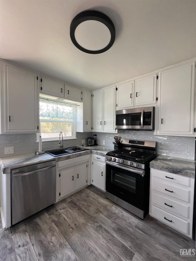 132 Franklin Ave, Taft, CA 93268 - kitchen with stainless steel appliances, white cabinetry, a sink, and backsplash