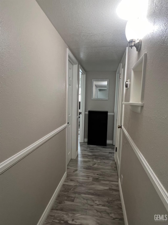 132 Franklin Ave, Taft, CA 93268 - hall with a textured ceiling, baseboards, and dark wood finished floors
