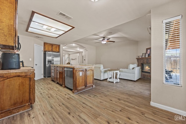 5502 Veneto St, Bakersfield, CA 93308 - kitchen with stainless steel appliances, ceiling fan, light wood-type flooring, and arched walkways