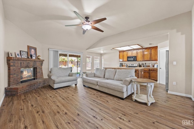 5502 Veneto St, Bakersfield, CA 93308 - living room with ceiling fan, wood finished floors, a brick fireplace, lofted ceiling, and baseboards