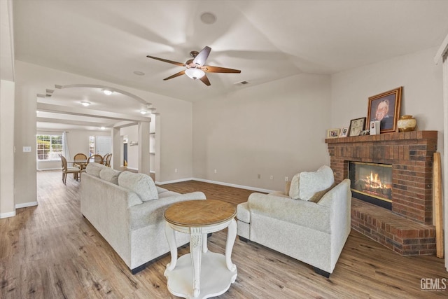 5502 Veneto St, Bakersfield, CA 93308 - living room featuring arched walkways, a fireplace, ceiling fan, wood finished floors, and lofted ceiling
