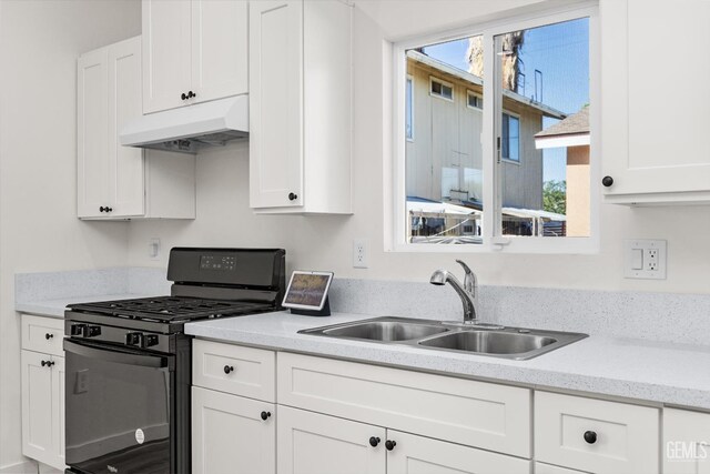 135 L St, Bakersfield, CA 93304 - kitchen featuring black range with gas stovetop, under cabinet range hood, white cabinets, and light stone counters