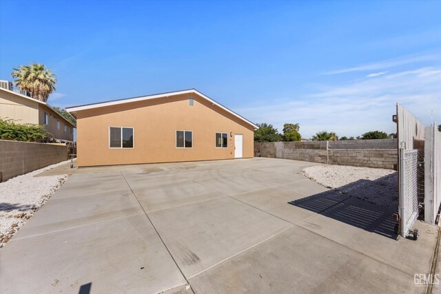 135 L St, Bakersfield, CA 93304 - view of property exterior featuring a fenced backyard, a patio area, and stucco siding