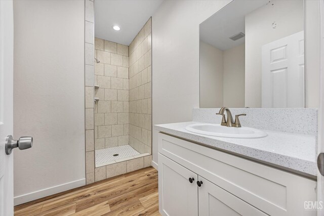 135 L St, Bakersfield, CA 93304 - bathroom featuring vanity, tiled shower, wood finished floors, and recessed lighting
