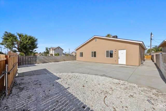 135 L St, Bakersfield, CA 93304 - rear view of property with a fenced backyard, a patio, and stucco siding