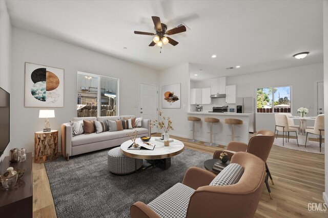 135 L St, Bakersfield, CA 93304 - living room with light wood finished floors, ceiling fan, and recessed lighting