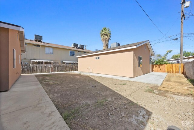135 L St, Bakersfield, CA 93304 - rear view of house with a fenced backyard, a patio, and stucco siding