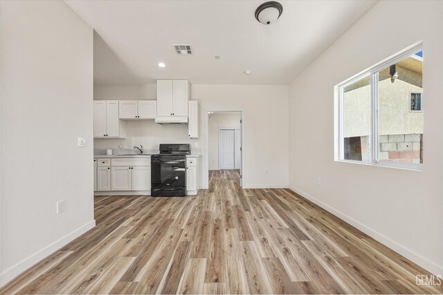 135 L St, Bakersfield, CA 93304 - kitchen featuring gas stove, white cabinets, light wood-type flooring, under cabinet range hood, and recessed lighting