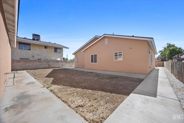 135 L St, Bakersfield, CA 93304 - view of home's exterior with a fenced backyard, a patio area, and stucco siding