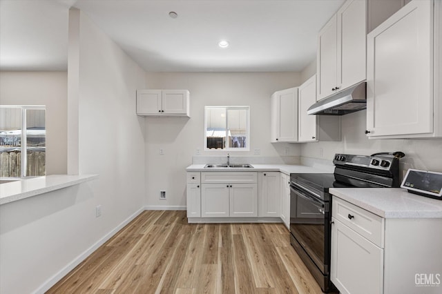 135 L St, Bakersfield, CA 93304 - kitchen featuring black electric range oven, under cabinet range hood, light wood-style flooring, white cabinets, and recessed lighting