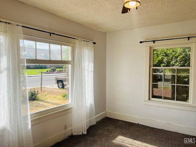323 A St, Bakersfield, CA 93304 - empty room featuring dark carpet, ceiling fan, a textured ceiling, and baseboards