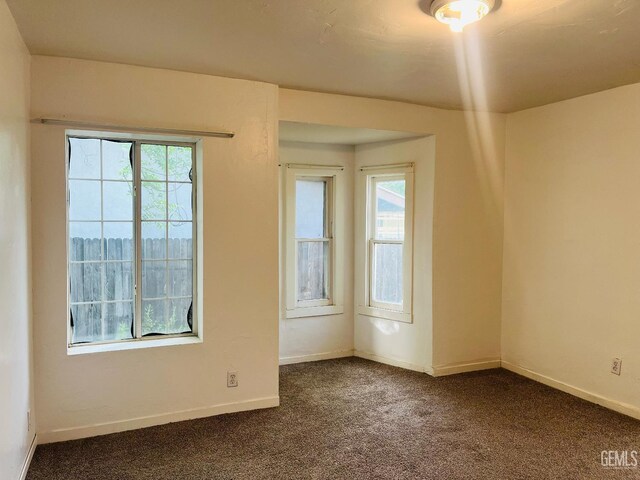 323 A St, Bakersfield, CA 93304 - empty room featuring dark colored carpet and baseboards