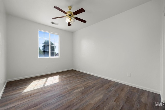empty room featuring baseboards, visible vents, and dark wood-type flooring