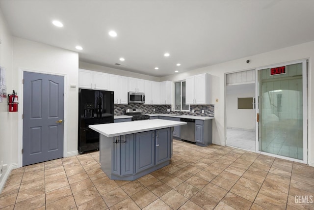 kitchen with light countertops, a center island, white cabinets, and stainless steel appliances