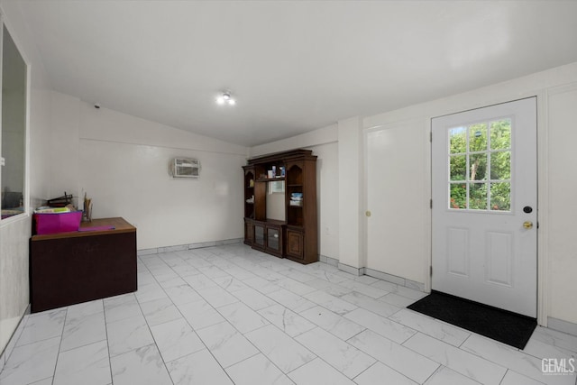 foyer with an AC wall unit, vaulted ceiling, and marble finish floor