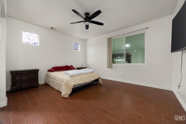 bedroom featuring ceiling fan, baseboards, visible vents, and wood finished floors