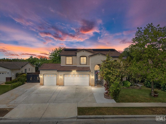 traditional-style house featuring driveway, solar panels, a tile roof, and stucco siding