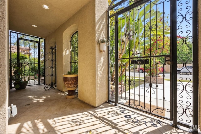 doorway to property featuring a gate and stucco siding