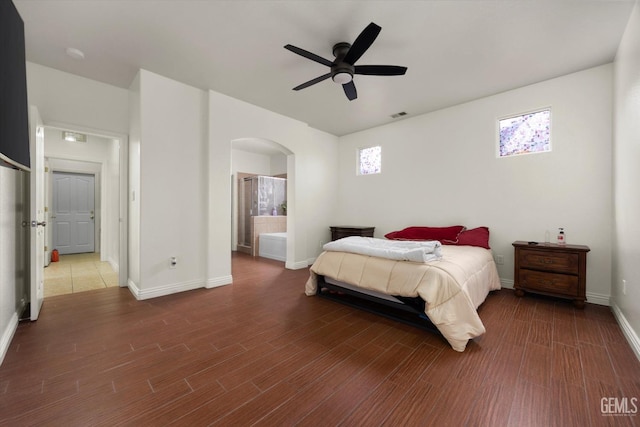 bedroom with visible vents, arched walkways, baseboards, and wood finished floors