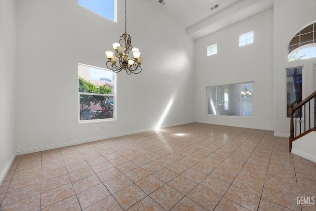 spare room featuring an inviting chandelier, light tile patterned floors, a high ceiling, and visible vents