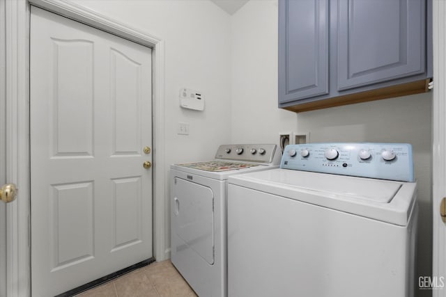 laundry area with independent washer and dryer, light tile patterned flooring, and cabinet space