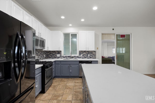 kitchen with a sink, appliances with stainless steel finishes, white cabinets, and gray cabinetry