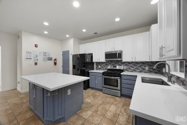 kitchen featuring stainless steel appliances, decorative backsplash, a sink, and white cabinetry
